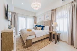 a bedroom with a large bed with blue pillows at Walk to Palm Beach! 5Bed Hottub with Pool 10people in Palm-Eagle Beach +70 photos