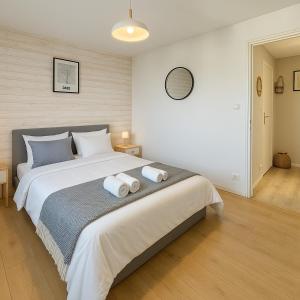 Bel appartement lumineux - quartier La Doutre - 4 personnes - في أنجيه: غرفة نوم بها سرير كبير مع مناشف عليه