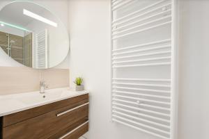 ein Badezimmer mit Waschbecken und Spiegel in der Unterkunft Spacieux 3 chambres et lumineux à Montrouge in Malakoff