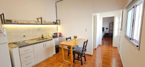 a kitchen with a wooden table and a counter top at LitStay Monoambiente in Córdoba +33 photos