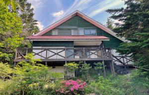 a green house with a red roof at HARUNA SKY Panoramic view of Nasu,private space surrounded by fir trees,relaxing stone bath,watching movies on a 120inch big screen in Nasu