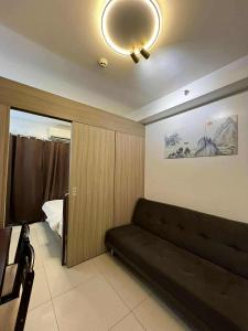 Una sala de estar con un sofá y un dormitorio. en SHORE Staycation in MOA by MLG, en Manila