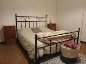 a bedroom with a bed with a wrought iron frame at La Lissandra Agriturismo House in Palagano