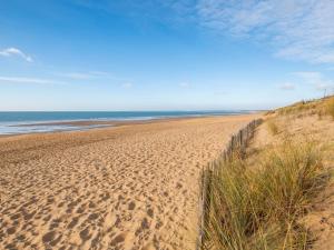 a sandy beach next to the ocean with a fence at Maison rénovée, animaux admis, proche plage et centre-ville - FR-1-194-296 in La Tranche-sur-Mer