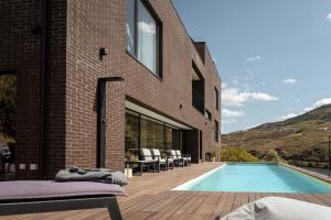 a house with a swimming pool next to a building at Casa do Ferrão in Covas do Douro