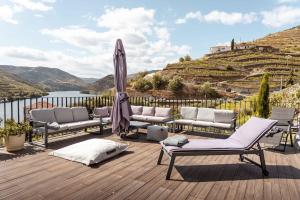 a deck with chairs and an umbrella and a view of a castle at Casa do Ferrão 