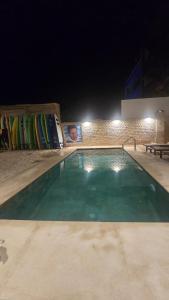 Una piscina de noche con tablas de surf en una pared. en Aloha Imsouane vue sur mer, en Imsouane