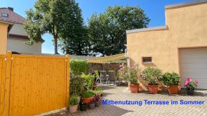 een achtertuin met een houten hek en potplanten bij Kim Ferienwohnung A in Sömmerda