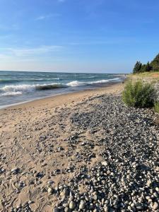 a sandy beach with rocks and the ocean at The Hampton House Luxury Rental in Southampton