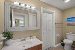 Un baño con lavabo, inodoro y espejo. en Coastal Breeze Siesta – Entire 4-Unit Complex with Dock, en Sarasota 42 fotos más