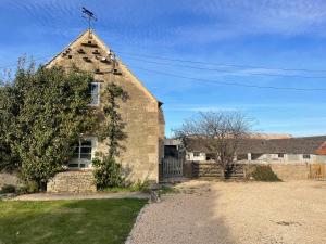 an old stone church with a cross on the roof at Stunning Countryside House with Pool and Hot Tub in Hankerton