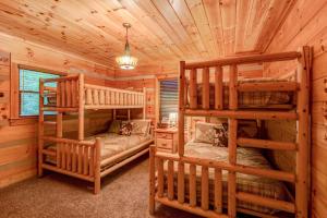 a bedroom with two bunk beds in a log cabin at Little Creek Lodge in Vilas