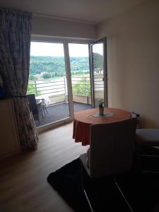a living room with a table and a large window at Rheinapartment Dependance 8 in Bad Hönningen