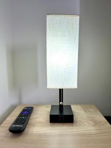 una lámpara sentada en una mesa junto a un mando a distancia en Estudio cerca del Movistar Arena, en Santiago