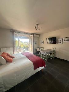 Un dormitorio con una cama y una mesa y una ventana. en Le Mas de l'Orangerie 3 etoiles, en Gréoux-les-Bains 132 fotos más