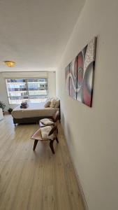 Apartamento en POCITOS vista al mar في مونتيفيديو: غرفة بسرير ومقعد وطاولة