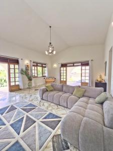 a living room with a large couch and a rug at Domaine Du Paradis in Le Robert