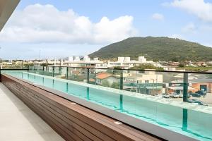 a view from the balcony of a building with a swimming pool at Loft Moderno, 500m Praia, Piscina, Sauna, WiFi 1GB in Florianópolis