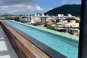 a large swimming pool on the roof of a building at Loft Moderno, 500m Praia, Piscina, Sauna, WiFi 1GB in Florianópolis