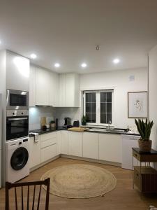a kitchen with white cabinets and a sink and a dishwasher at Golega Boutique Apartment By Gt House in Golegã