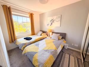 two beds in a room with a window at Inverness Holiday Retreat - 2 Bedroom in Inverness