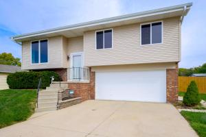a house with a white garage door at Pet-Friendly Omaha Vacation Rental with Deck! in Omaha
