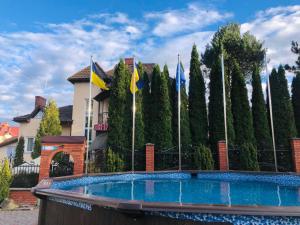 a swimming pool with flags in front of a building at Red Stone in Truskavets