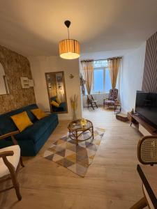 a living room with a blue couch and a table at Joli appartement au pied du beffroi in Arras