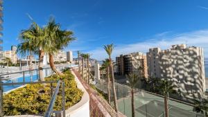 a view of a city with palm trees and buildings at SUNSET CLIFFS fantastic apartment in Benidorm