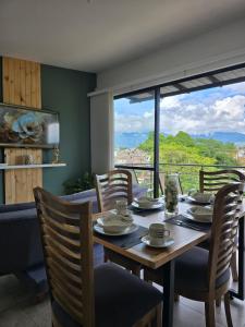 a dining room with a table and chairs and a large window at CASA Y APARTAMENTOS PRIVADOS 2 y 3 habitaciones, PISCINA, JACUZZY, SAUNA cerca Aeropuerto, parque Del Cafe By Molca Xperiences in Armenia +41 photos