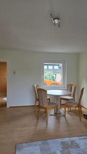 Una habitación con una mesa y sillas y una ventana. en Haus 21, en Bad Nenndorf