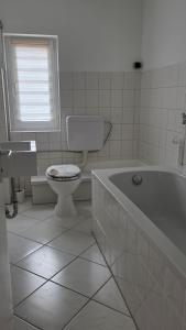 Un baño con inodoro, bañera y lavabo. en Haus 21, en Bad Nenndorf