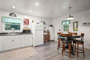 a kitchen with white appliances and a table and chairs at Rustic Cabin Getaway Close to Everything Fun! in Beaver Dams +9 photos