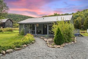 a small gray house with a gravel driveway at Rustic Cabin Getaway Close to Everything Fun! in Beaver Dams