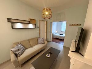 a living room with a couch and a television at Charmant T2 en RDC Centre Douai Netflix in Douai