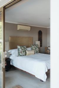 a bedroom with a large bed with white sheets and pillows at Whale Away Guest House in Hermanus +23 photos