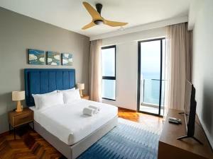 Tanjong TokongにあるPenang Beachfront Seaview Residencesのベッドと天井扇風機のある寝室 +55枚の写真