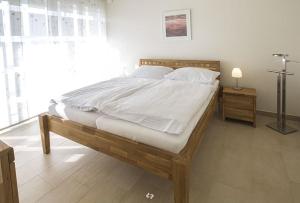 une chambre avec un grand lit avec des draps blancs dans l'établissement WINDLICHT App Nr 3 max 4 Pers, à Dierhagen