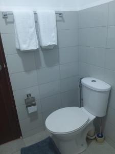 a bathroom with a white toilet and towels at SkyLine 19 Apartment in Colombo