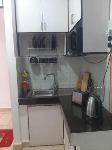 a kitchen with a sink and a microwave at SkyLine 19 Apartment in Colombo