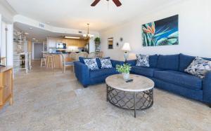 Phoenix X 1513 condo في شاطئ أورانج: غرفة معيشة مع أريكة زرقاء وطاولة