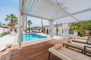 a house with a swimming pool and a patio at Walk to Palm Beach! 5Bed Hottub with Pool 10people in Palm-Eagle Beach