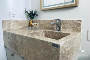 a marble sink in a bathroom with a mirror at Apartamento Novo Aconchegante e Moderno em Canela in Canela +87 photos
