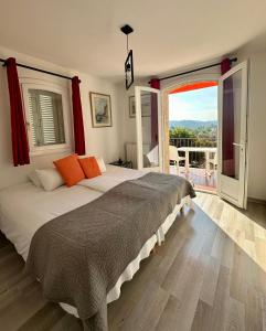 Un dormitorio con una cama grande y una ventana grande. en Le Mas de l'Orangerie 3 etoiles, en Gréoux-les-Bains