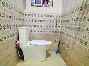 a bathroom with a white toilet in a room at Pokhara Apartment & Homestay in Pokhara