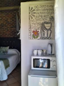 a room with a microwave and a bed in it at Pumba's B&B in Sannieshof +20 photos