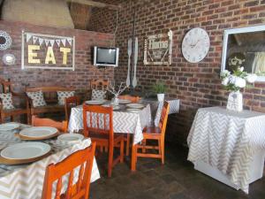 a dining room with tables and chairs and a clock at Pumba's B&B in Sannieshof