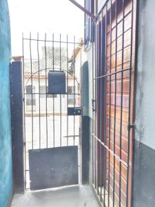 an open door with a gate with a television on it at suíte feliz in Belém