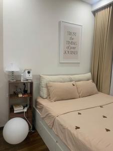 a small bedroom with a bed with a sign on the wall at Vinhomes Smart City by Chill D Homestay in Phú Thú