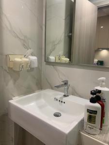 a bathroom with a white sink and a mirror at Vinhomes Smart City by Chill D Homestay in Phú Thú